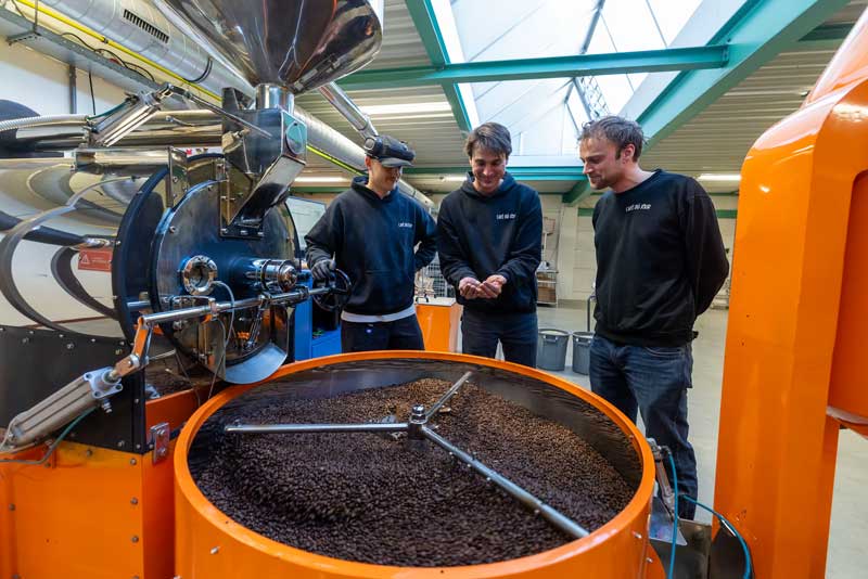 I fratelli dietro Café du Jour accanto al tostatore nella loro torrefazione